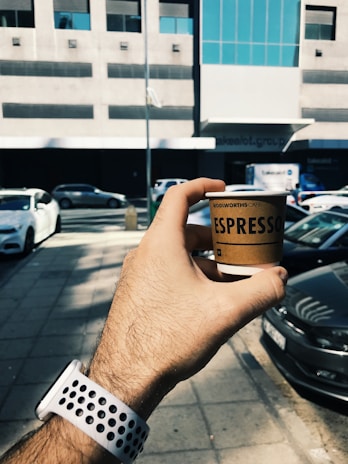 A drone delivering coffee to a customer in an urban setting.