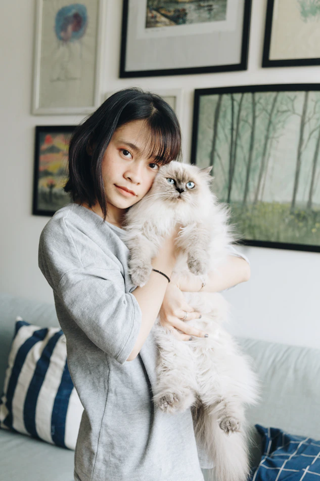 Woman holding cat in living room