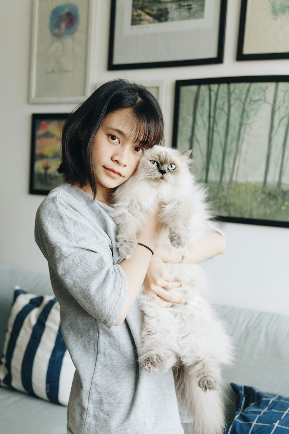woman carrying cat inside living room