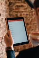 A friendly customer reviewing service plans on a tablet with a cup of coffee nearby.