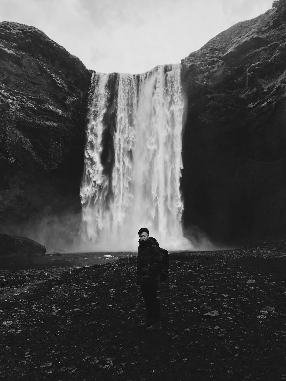 man standing in front of waterfalls