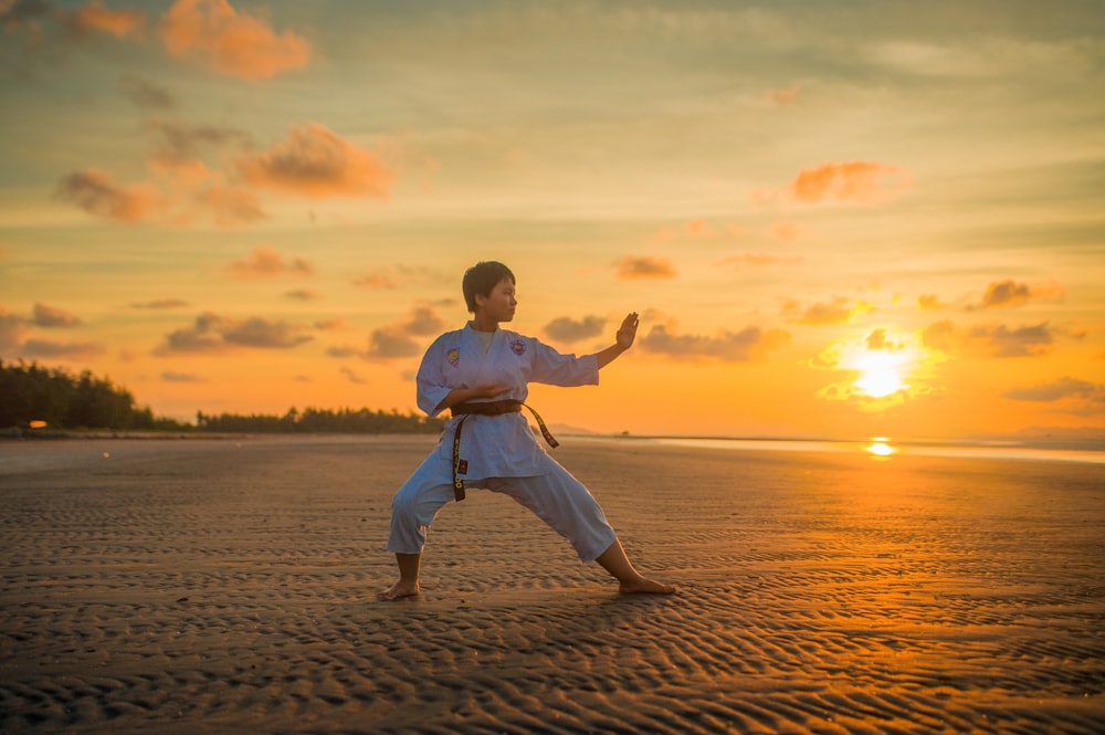 Junge macht Karate-Routinen während der goldenen Stunde