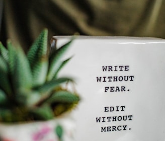 a white box with writing on it next to a plant