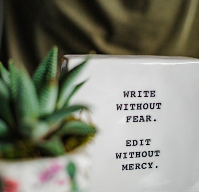 a white box with writing on it next to a plant