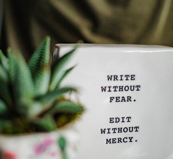 a white box with writing on it next to a plant