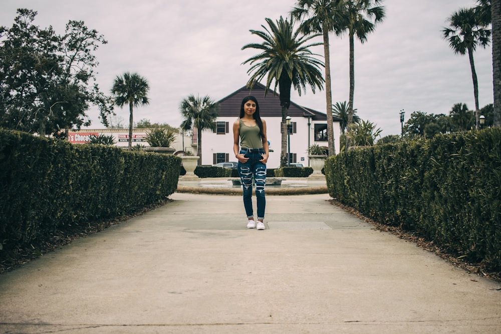 woman standing between hedges