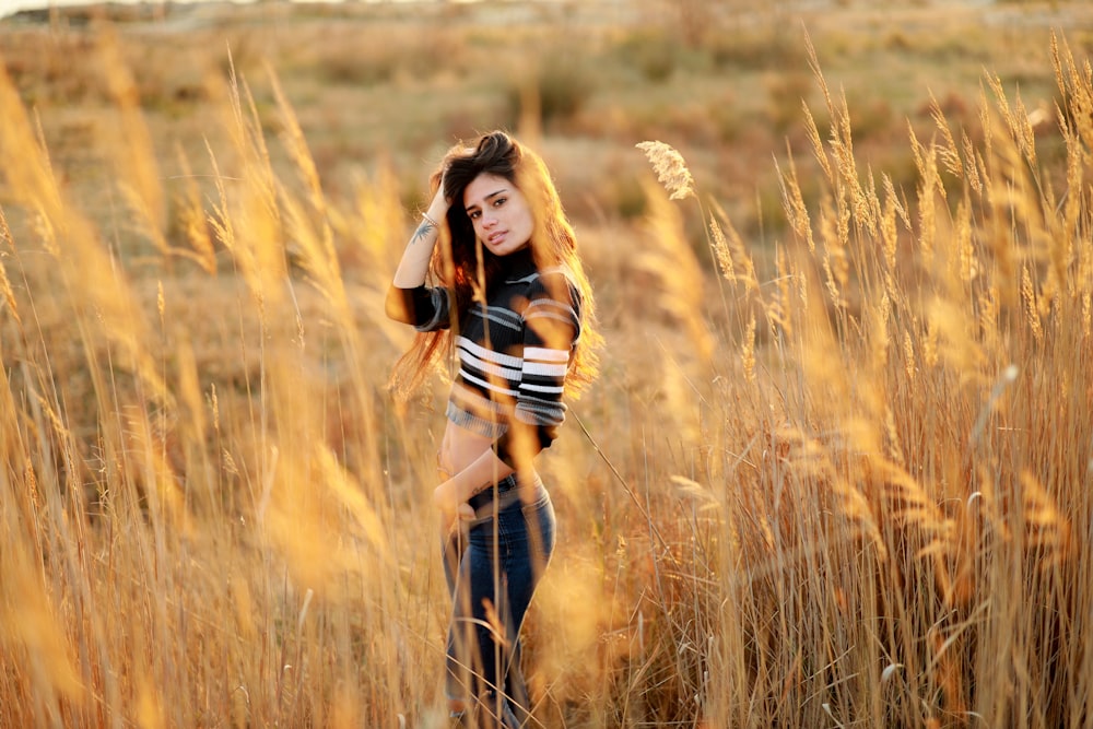 茶色の干し草に囲まれて立っている女性