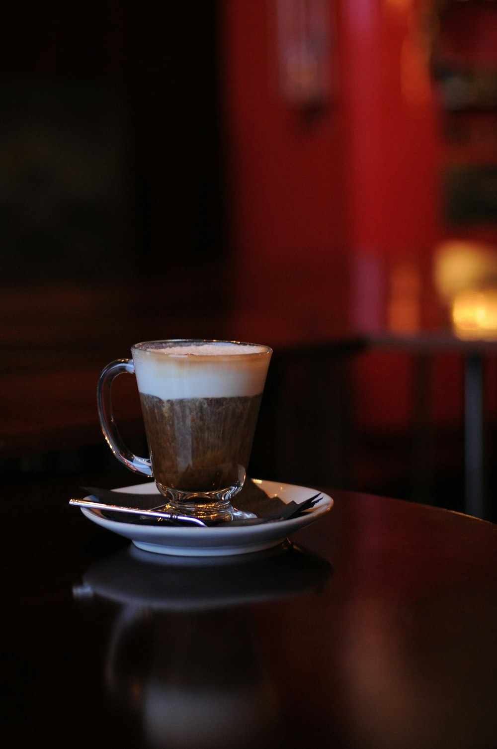 selective focus photo of clear-glass mug with saucer