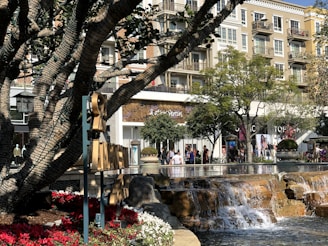 A vibrant retail center bustling with shoppers and colorful storefronts on a sunny day.