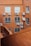 A view of an exterior wall of a building with red brick construction. Several air conditioning units are mounted on the wall below the windows, with wiring visible running along the brick surface. The shot is taken from a higher vantage point, overlooking a section of the building.