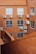 A view of an exterior wall of a building with red brick construction. Several air conditioning units are mounted on the wall below the windows, with wiring visible running along the brick surface. The shot is taken from a higher vantage point, overlooking a section of the building.