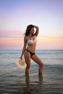 photography poses for pool & beach,how to photograph model enjoying the sunset ; woman in bikini posing on seashore