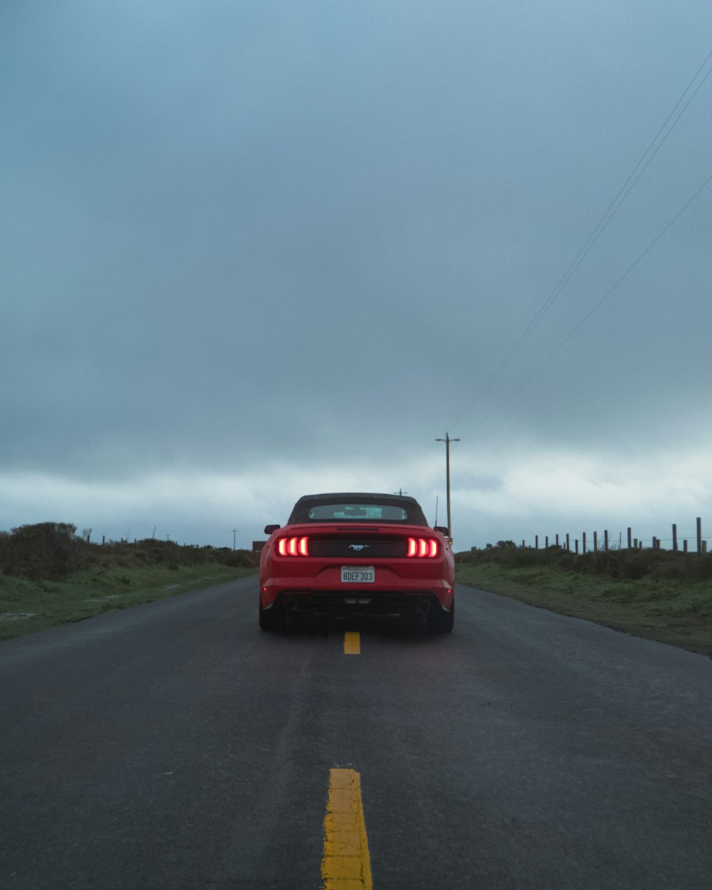 red Ford Mustang coupe at road