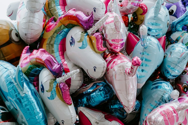 Colorful unicorn-themed foil and latex balloons in pink, purple, and gold