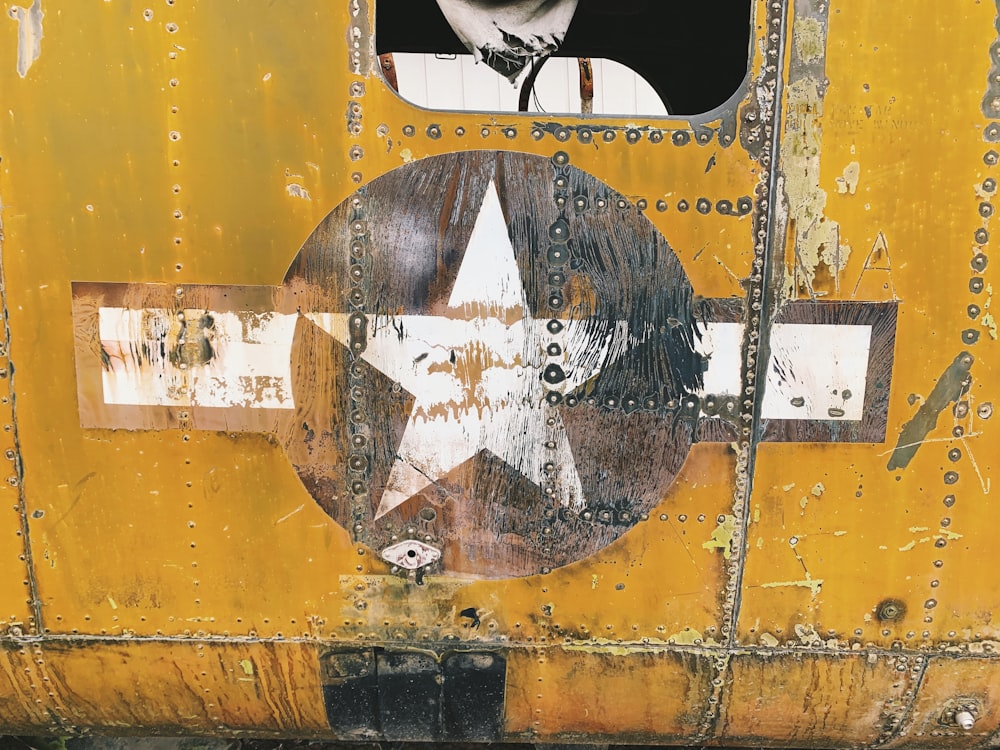 a yellow truck with a star painted on the side of it