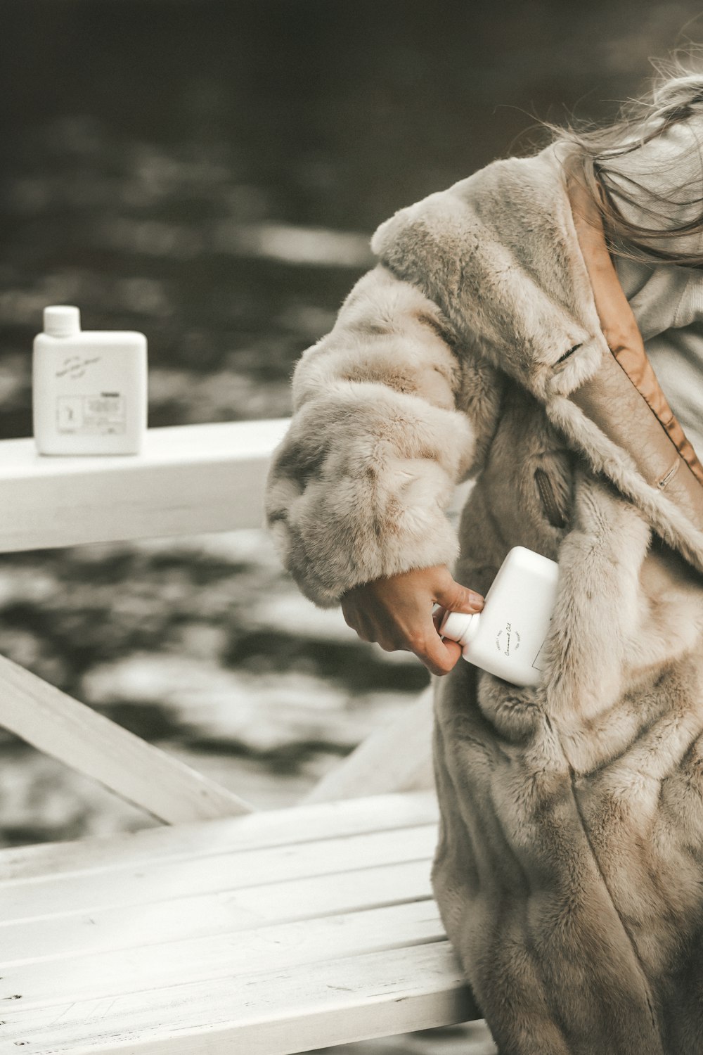 a woman in a fur coat sitting on a bench