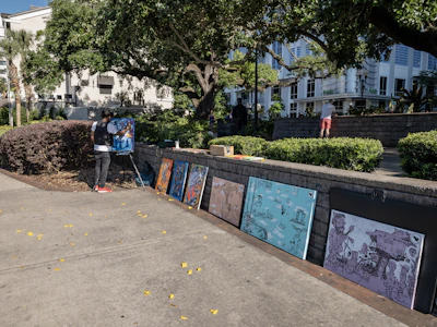 Participants happily painting outdoors in a lush Central Florida garden setting.