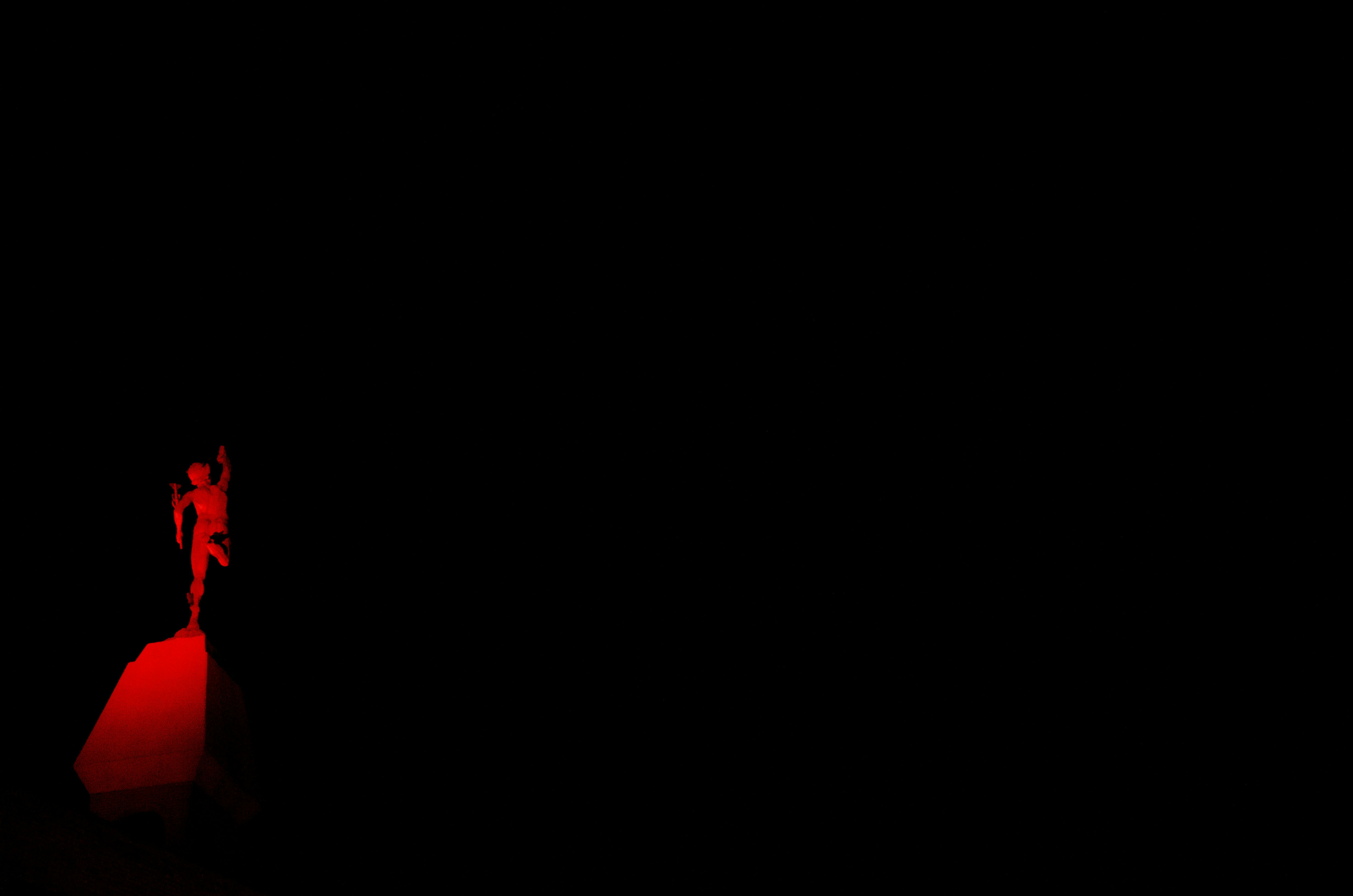 a person standing on top of a red object in the dark