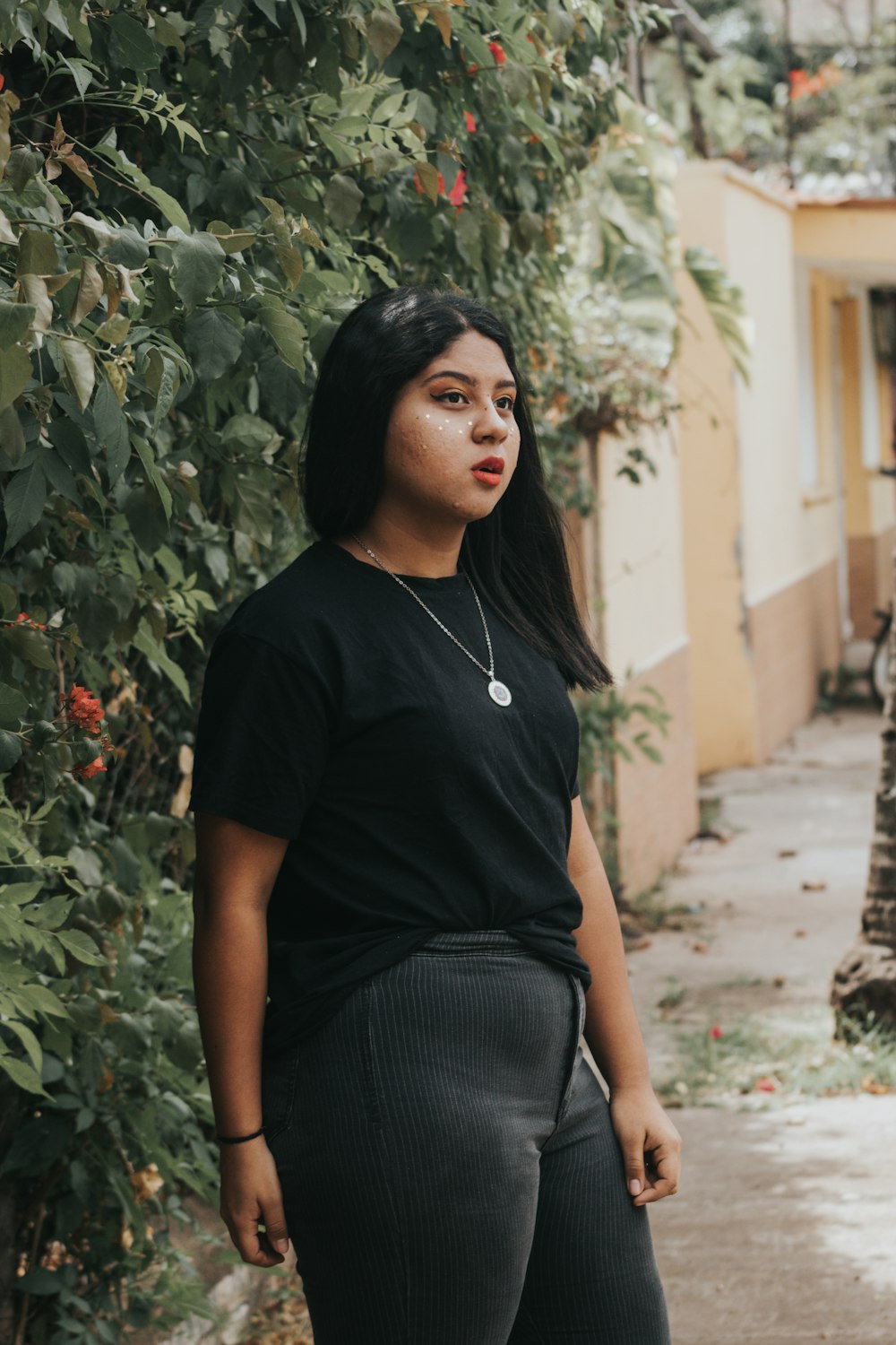 woman in black t-shirt standing near plant