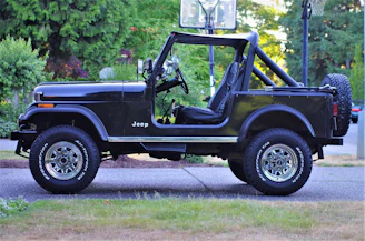 A Jeep parked outside the shop with a happy customer shaking hands with the mechanic.