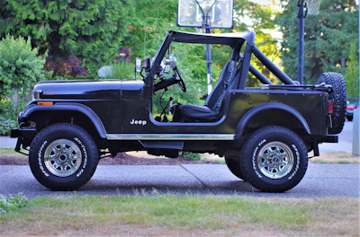 A Jeep parked outside the shop with a happy customer shaking hands with the mechanic.