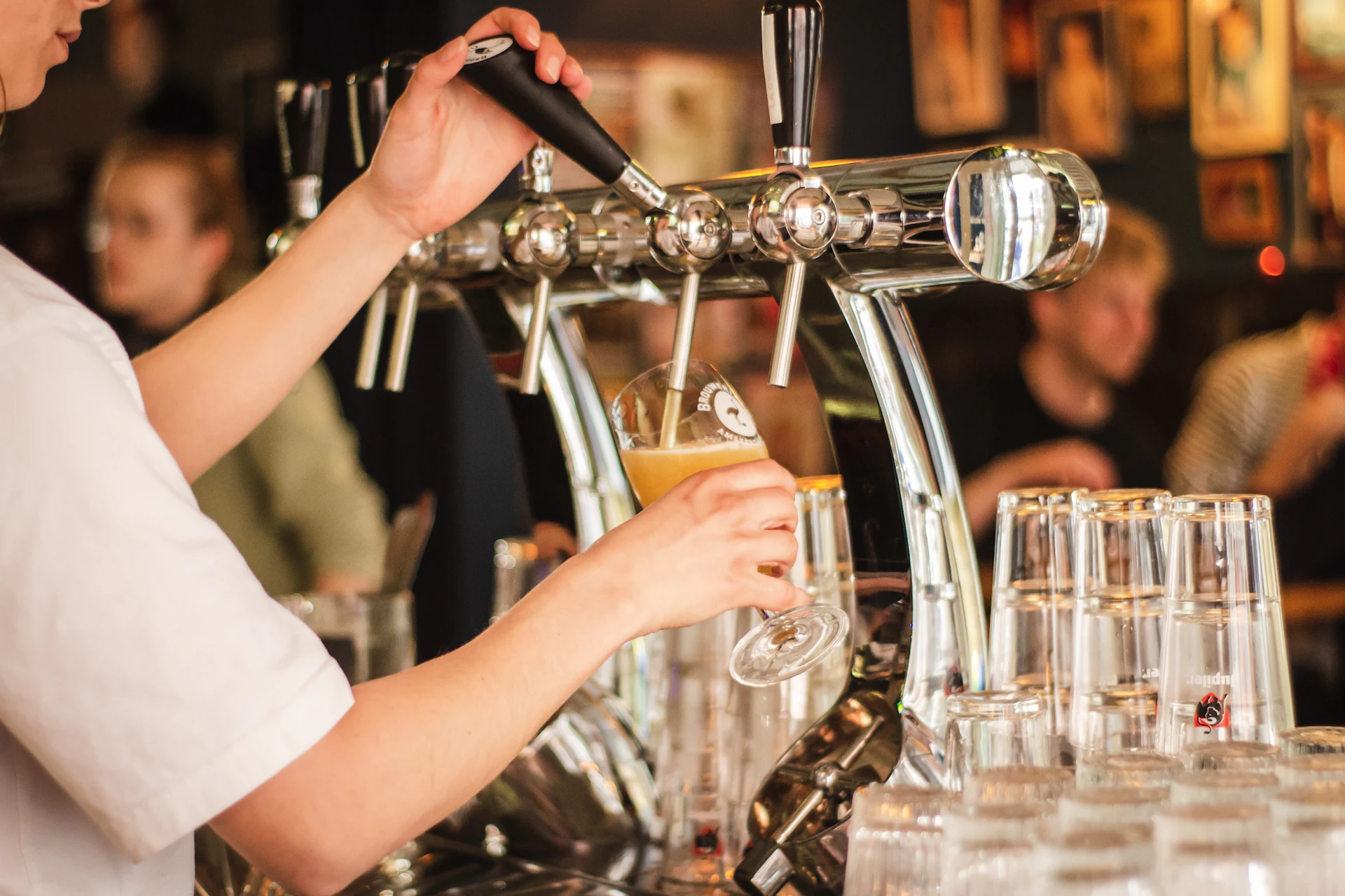 A bartender pulling a fresh pour at the taps