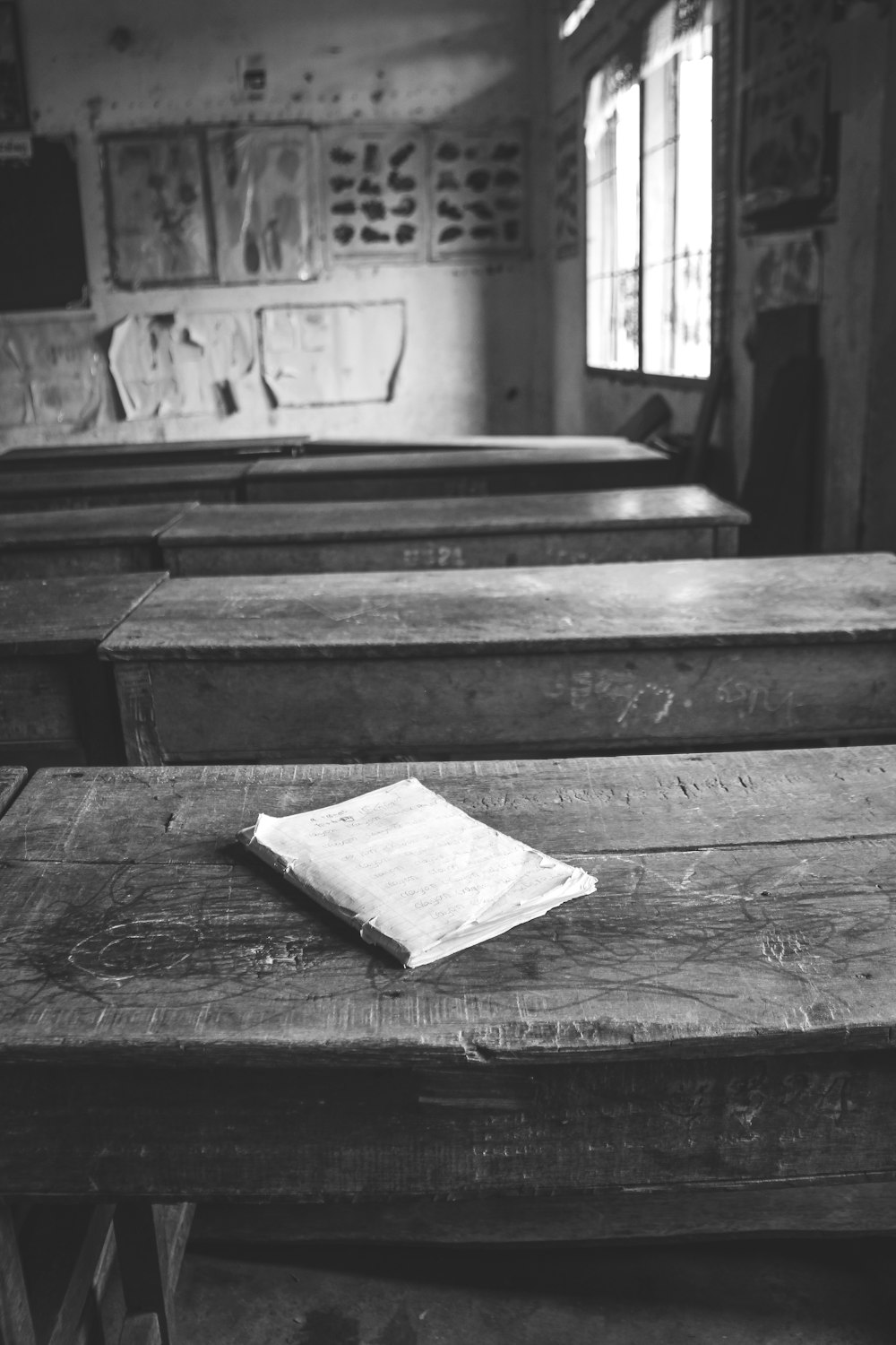 grayscale photo of book on wooden table