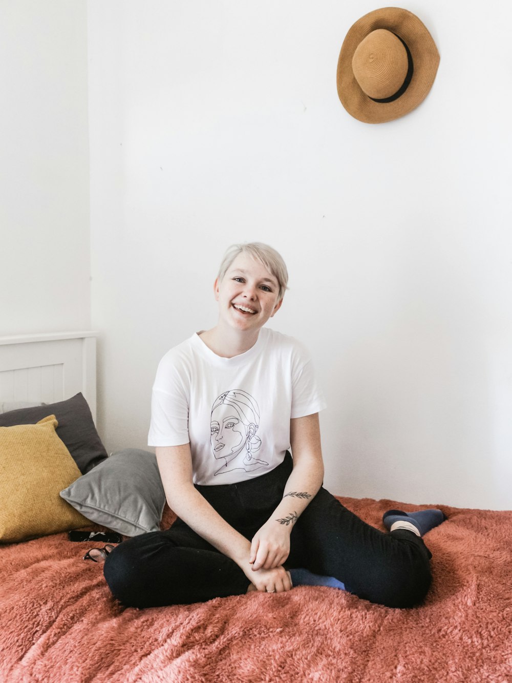 smiling woman sitting on bed