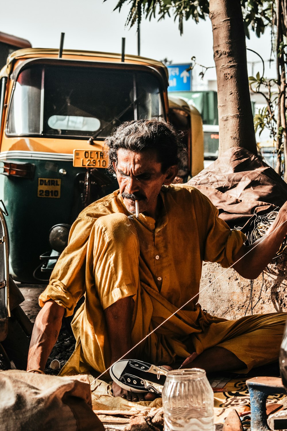 man sitting on floor near rickshaw during daytime