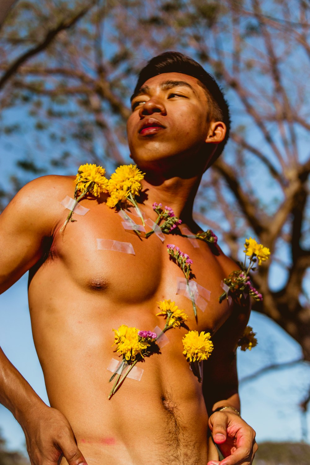 man standing under green tree