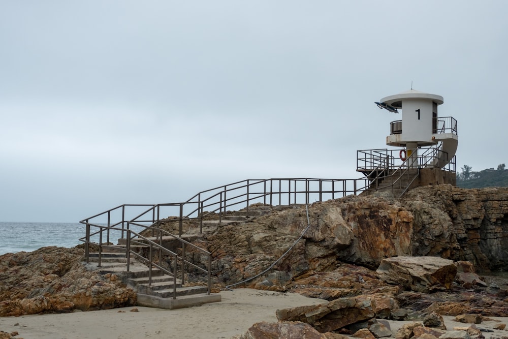watch tower on rock formation facing ocean