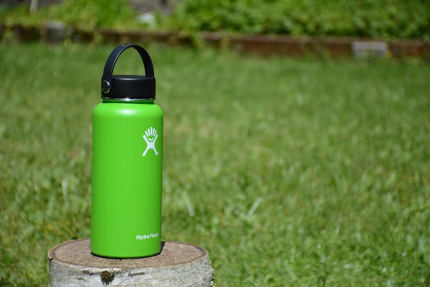 A vibrant, colorful water bottle surrounded by splashes of water, showcasing durability and fun.