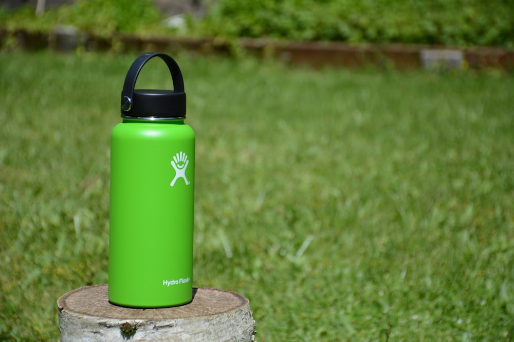 green Hydro Flask tumbler on wood slab