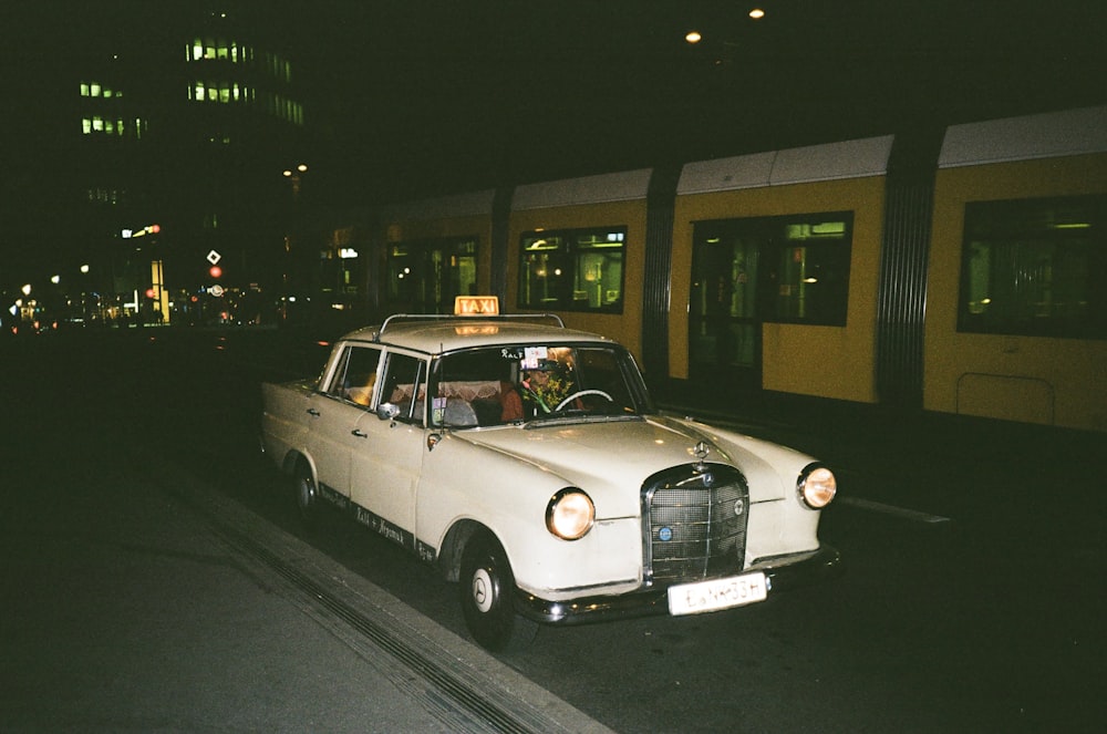 parked white sedan beside train