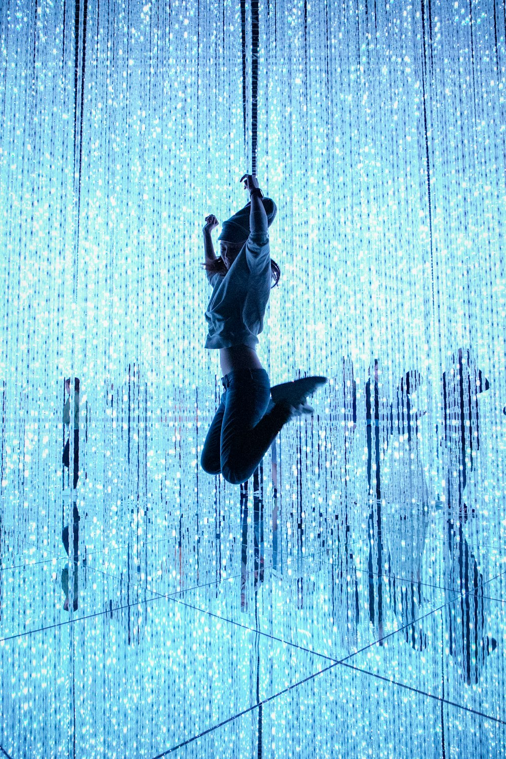 mujer saltando frente a la cadena de luces