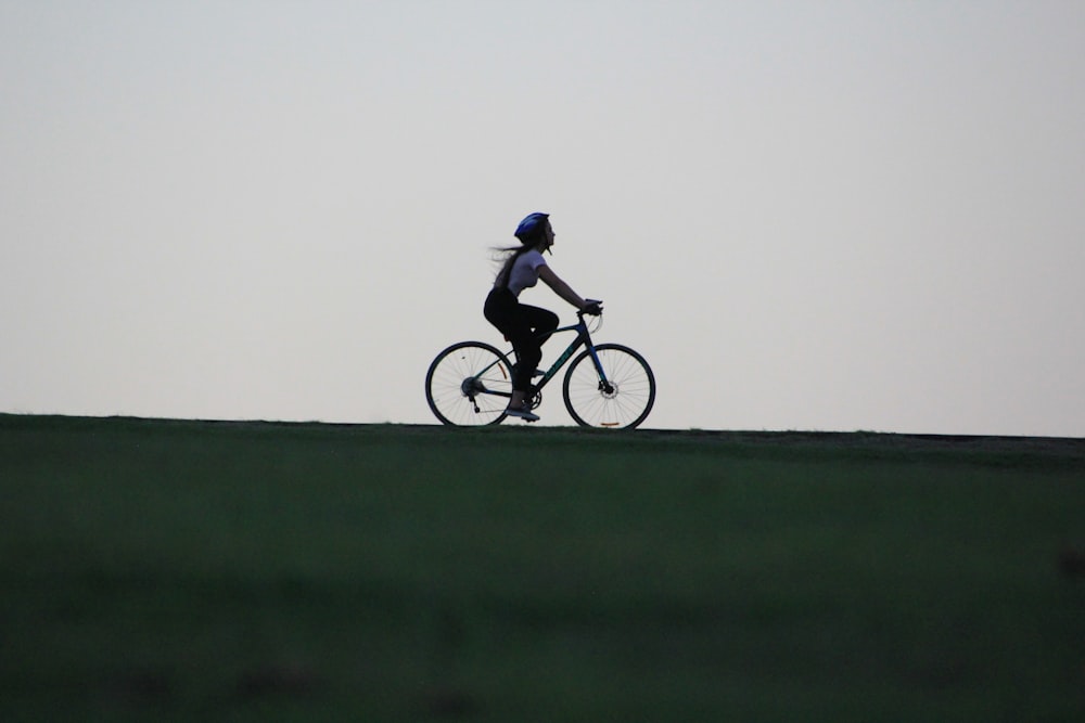 woman riding bike atop of hill