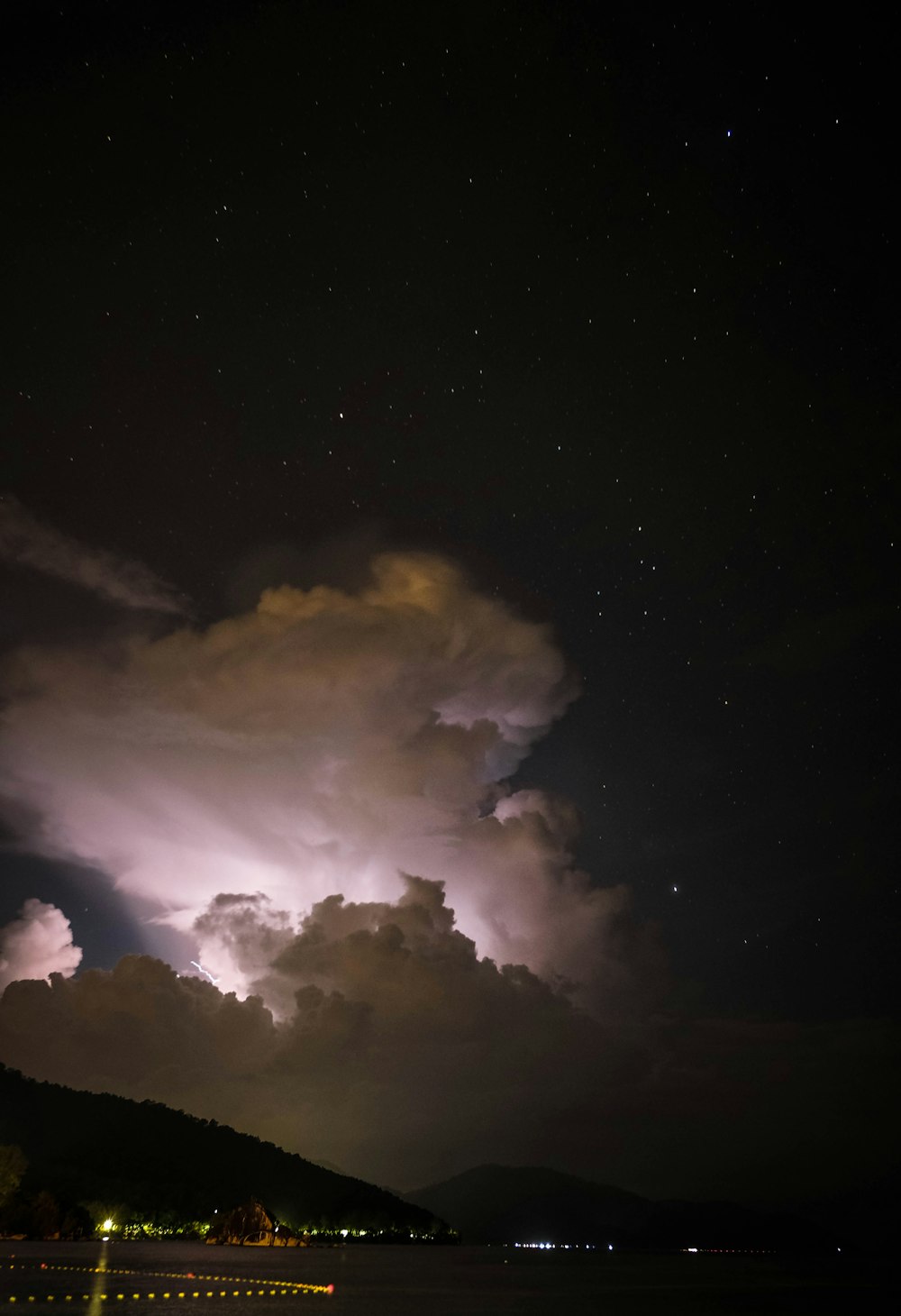 photo de paysage de montagnes sous ciel nuageux pendant la nuit
