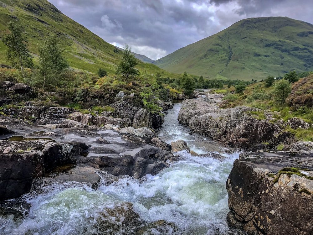 river near mountain at daytime