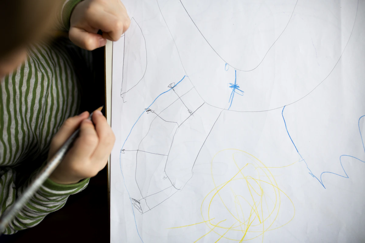 Child drawing and sketching on white paper