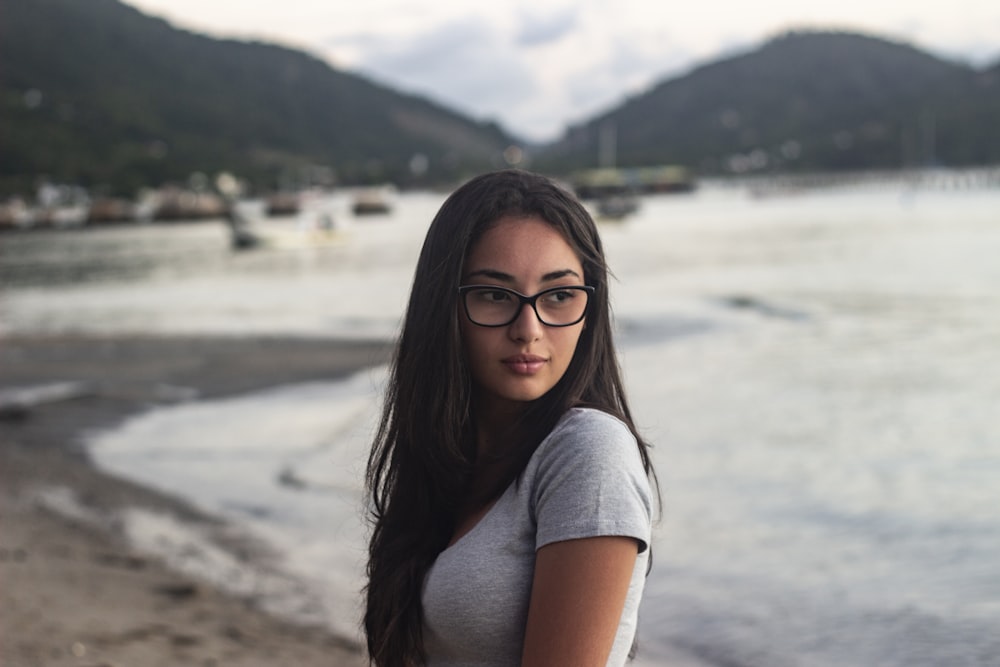 woman in gray shirt at shore wearing eyeglasses