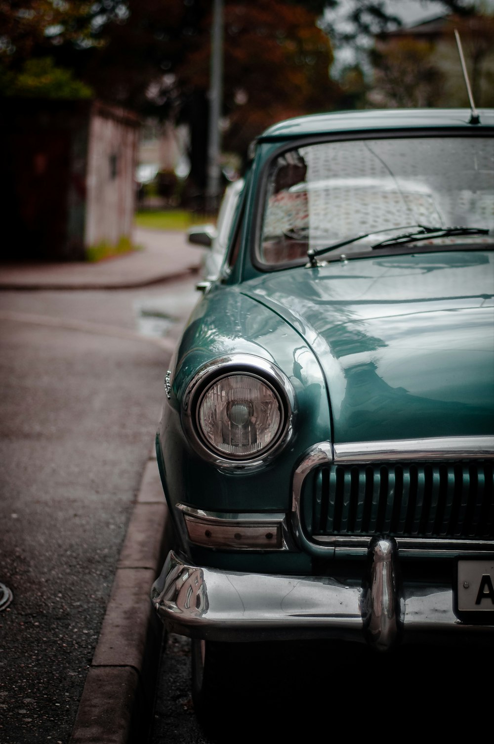 vintage green vehicle parked on sidewalk