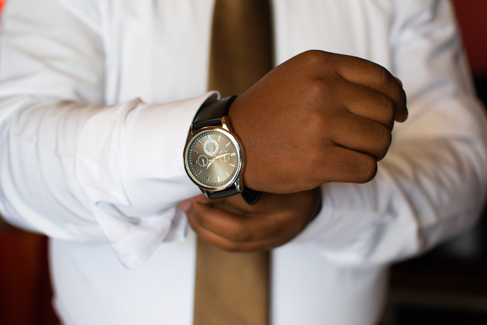 man wearing white dress shirt and black watch