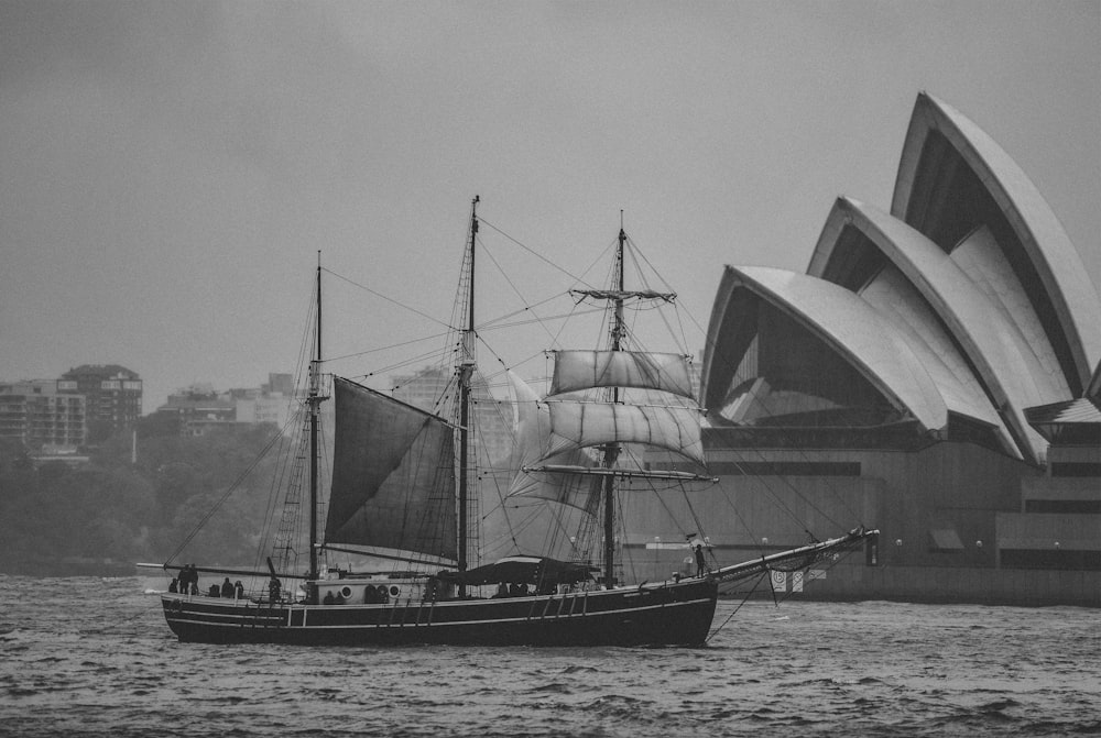 grayscale photography of ship beside Sydney Opera House