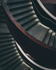 A beautifully crafted wooden staircase with sleek metal railings in a bright, modern home interior.
