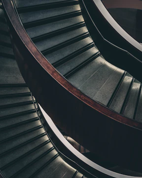 Renovated staircase with sleek wooden steps and matching plinths in a contemporary home.