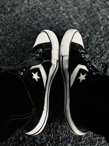 A stylish pair of classic All Star sneakers on a vibrant urban sidewalk.