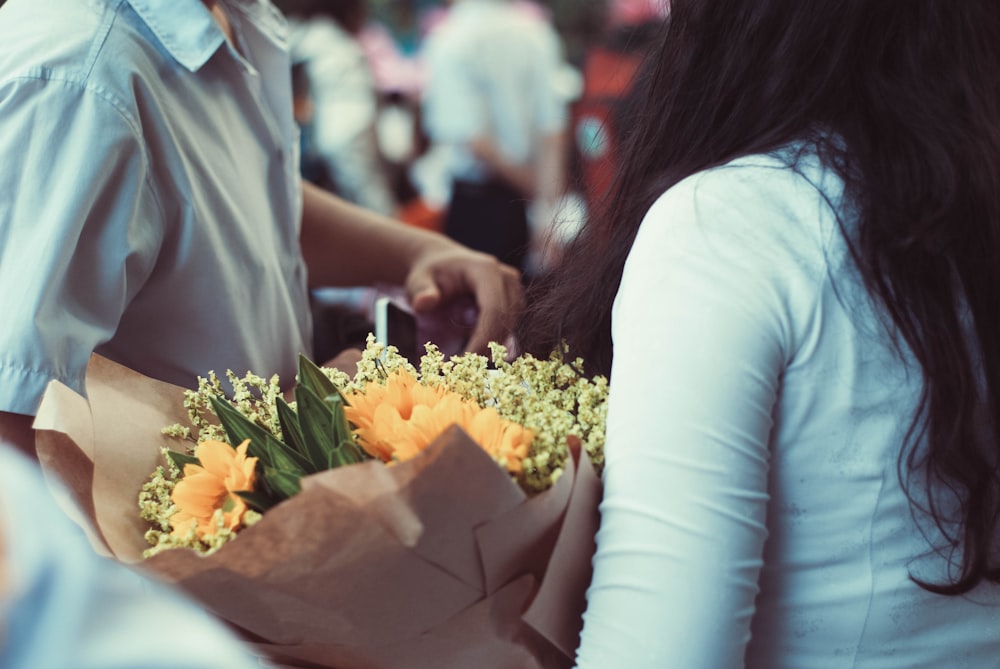 femme tenant un bouquet de fleurs