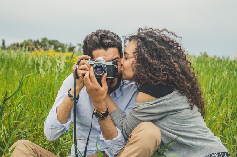 Couple with camera on grass