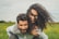 woman riding on man's back on green field