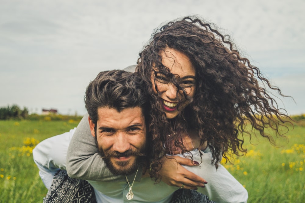 Femme chevauchant sur le dos de l’homme sur un champ vert